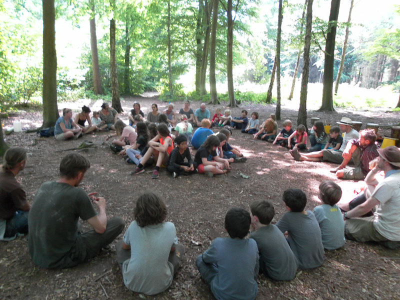 children sitting in forest