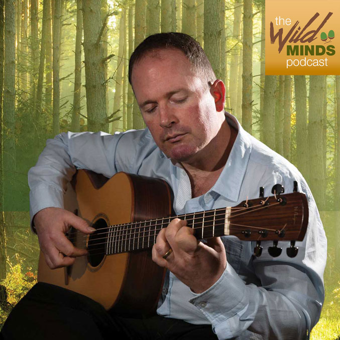geoff-robb Geoff Robb with guitar in front of trees