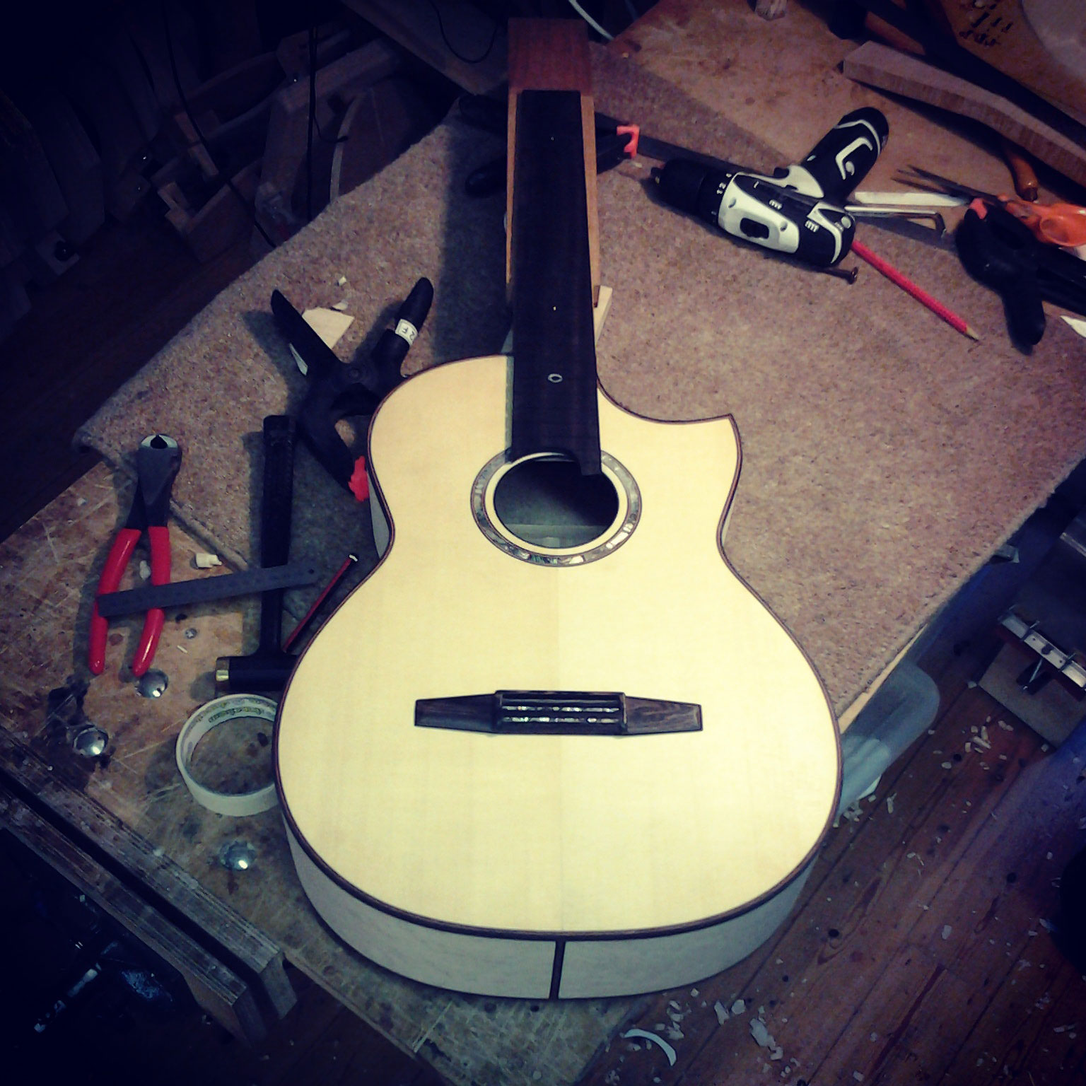 hand made maple guitar on workshop bench